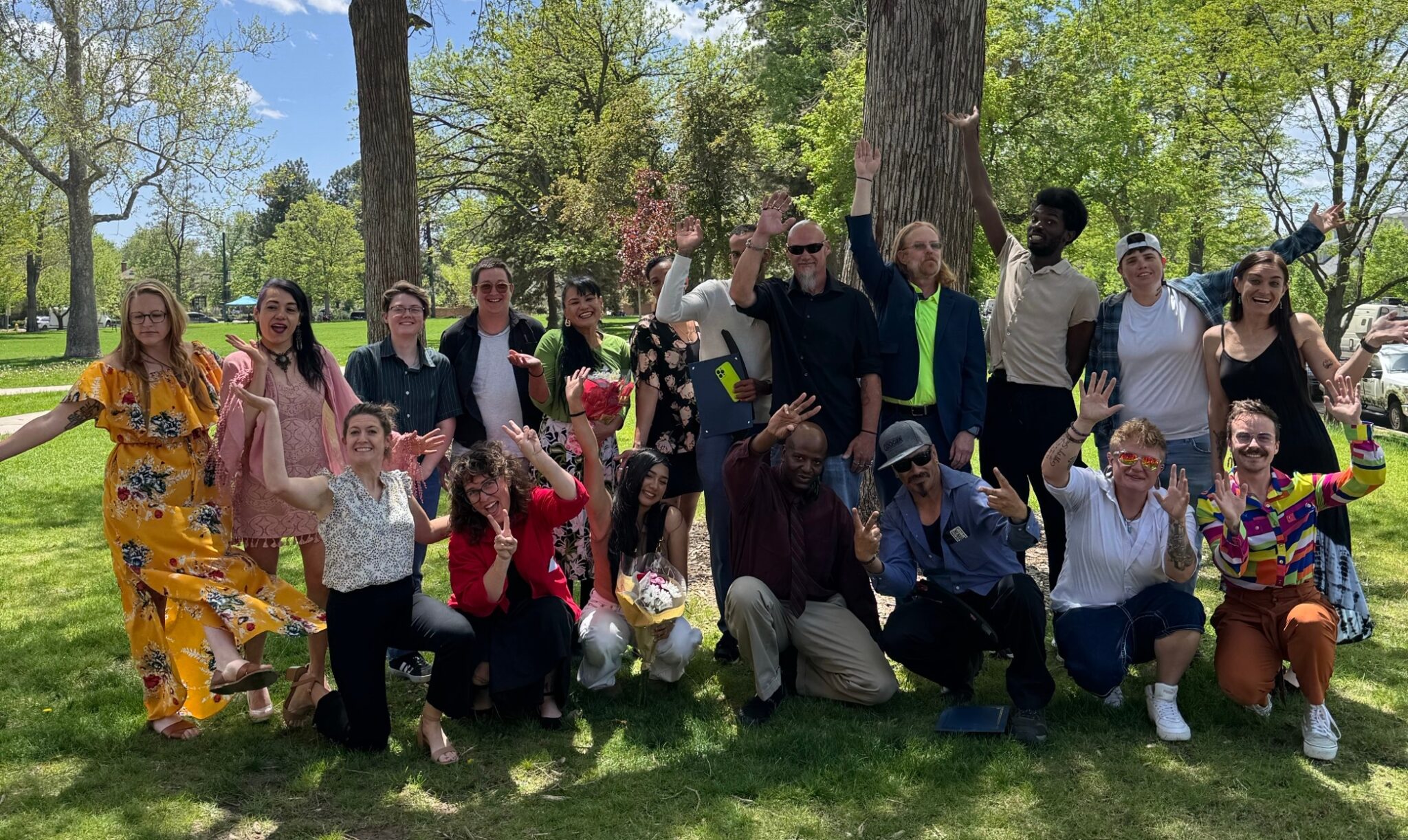 group of smiling people in a park