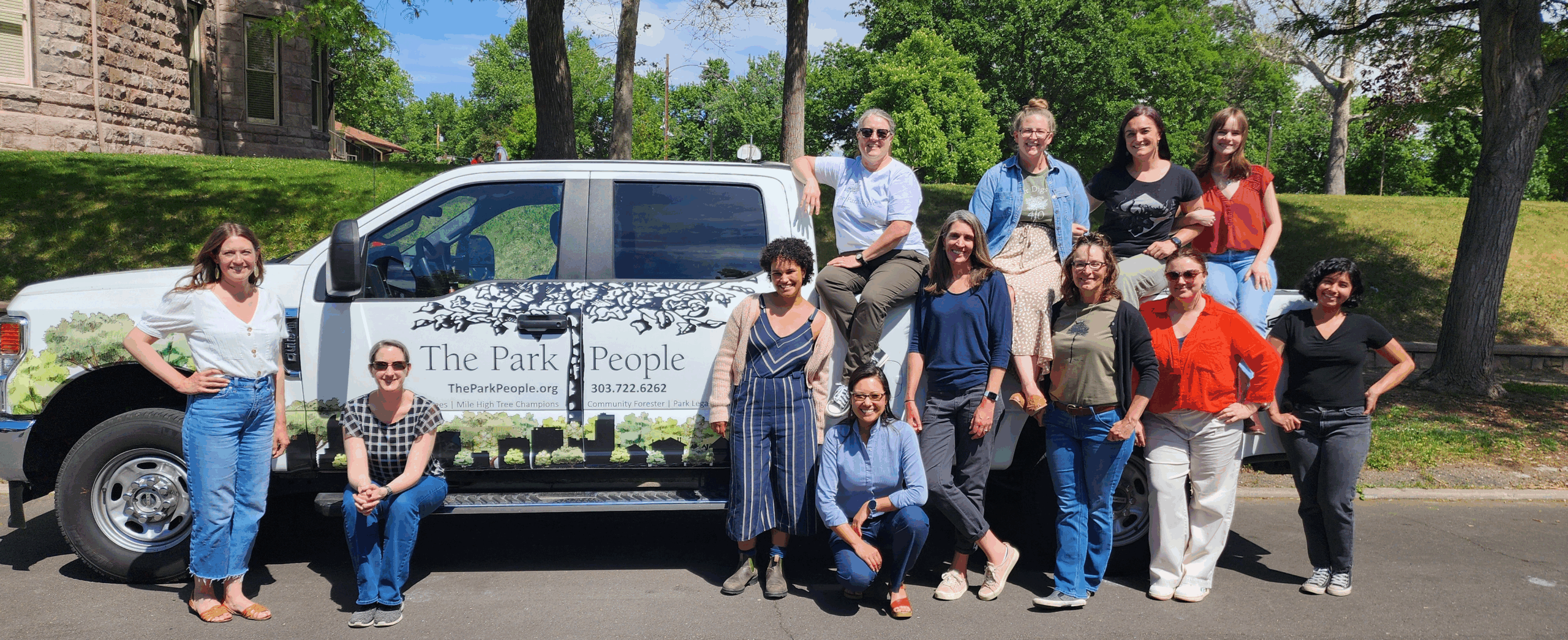 photo of smiling staff members in front of work truck
