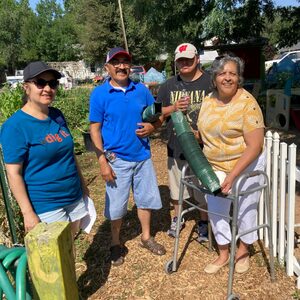 Barnum Garden Group of four adults, two women, and two men, stand together in a garden, smiling at the camera
