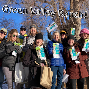 Group of smiling people wearing hats and gloves, with blue sky and leafless trees, behind them. They're holding up flyers that say Denver Digs Trees. Label says "Green Valley Ranch!"