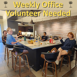 Group of smiling, casually dressed people sitting around a bar in an office kitchen, looking at the camera smiling. Label says, Weekly Office Volunteer Needed.